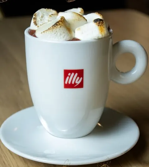 Xícara illy com marshmallows tostados, sobre o pires